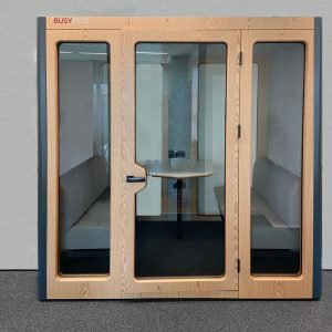 Cabina insonorizada oficina con sofas y mesa videoconferencia